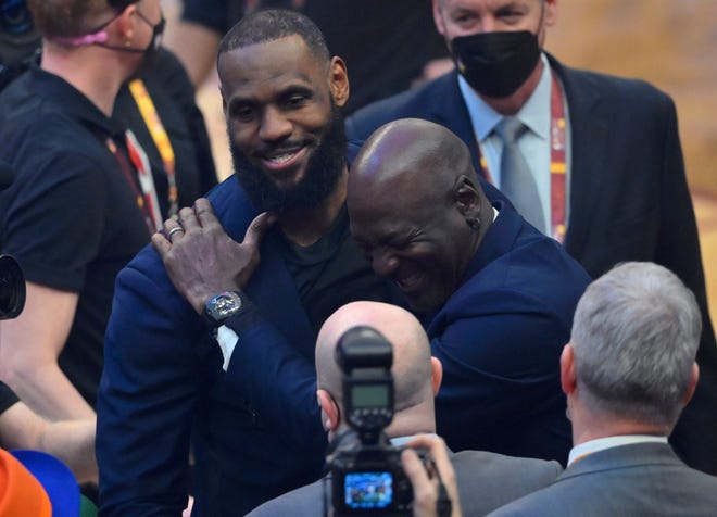 LeBron James y Michael Jordan se ríen durante la ceremonia de medio tiempo en honor al equipo del 75.° aniversario de la NBA.