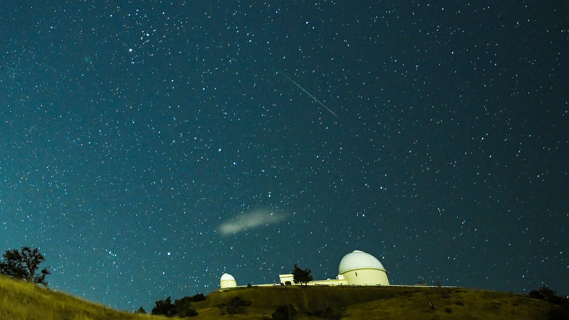 Un meteorito atraviesa el cielo nocturno sobre el Observatorio Lick durante la lluvia de meteoritos de las Perseidas.