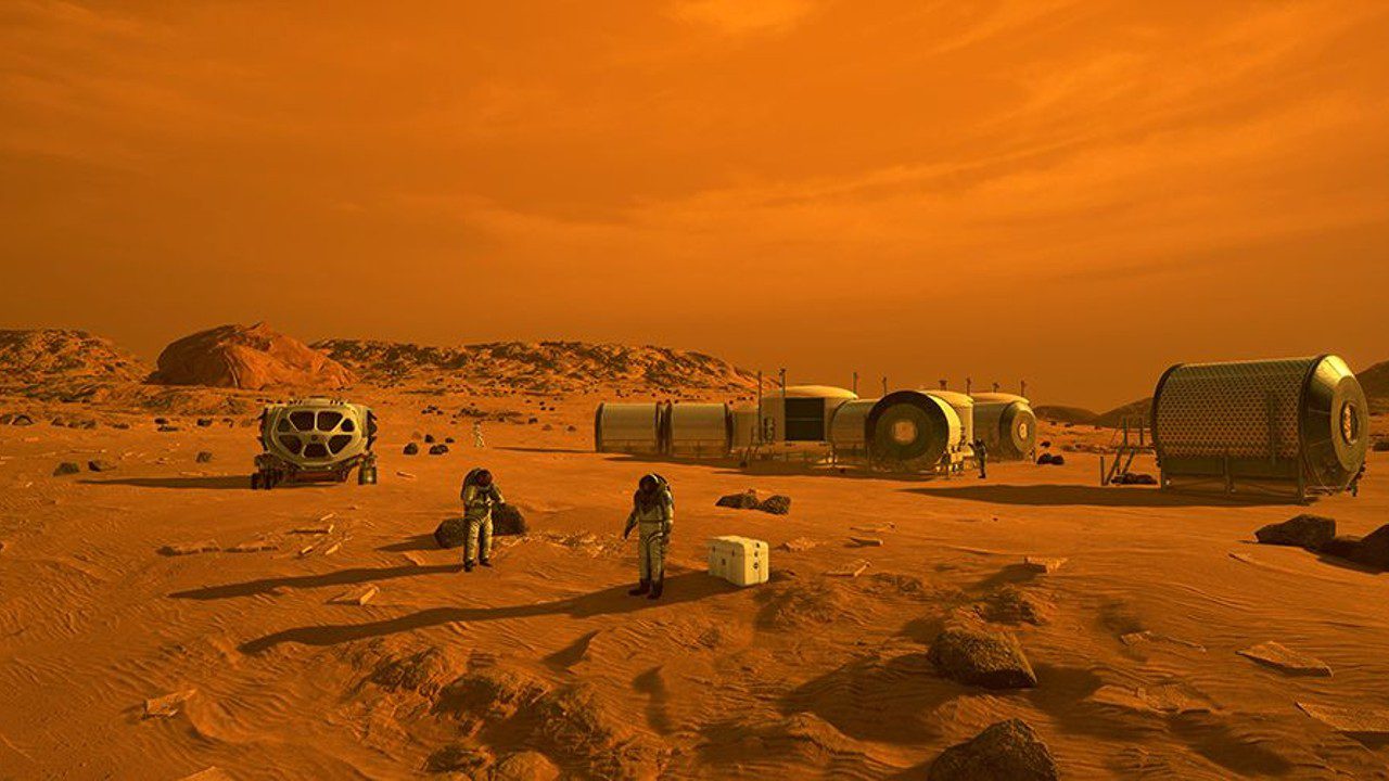 Personas con trajes espaciales en Marte rodeadas de edificios metálicos