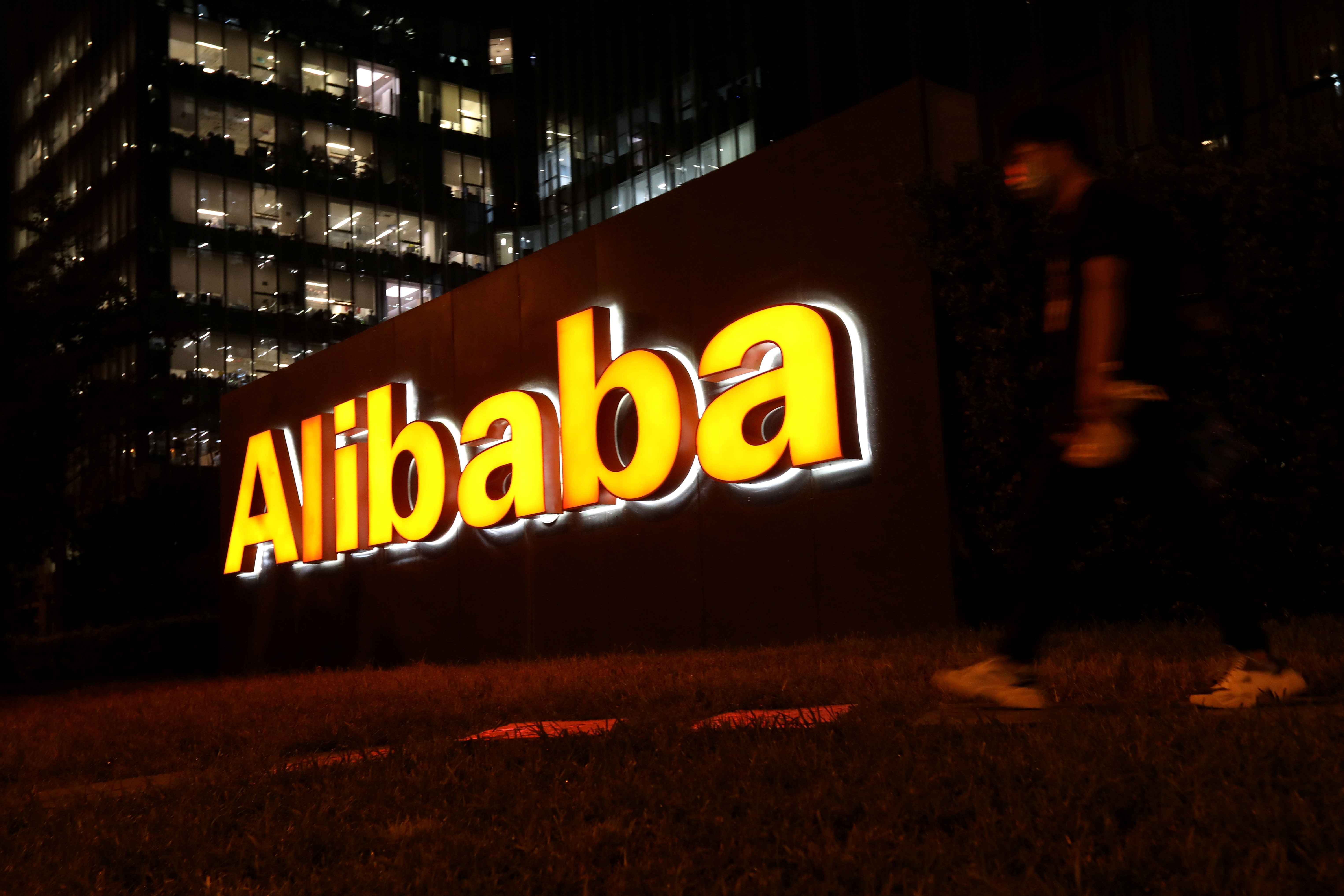 Un hombre camina cerca del logo del Grupo Alibaba en su edificio de oficinas en Beijing.