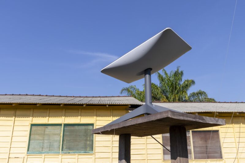 Una antena parabólica de banda ancha Starlink se encuentra sobre una mesa afuera.
