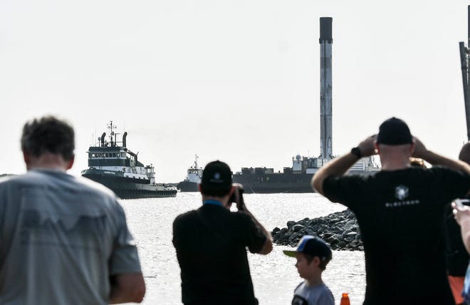 Los espectadores ven el regreso del propulsor de la primera etapa de SpaceX a Puerto Cañaveral a bordo del barco Just Read the Instrucciones el 4 de julio de 2020.